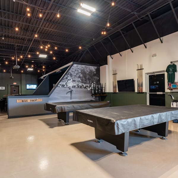 Interior of 731 Sports Bar and Grill with two covered pool tables and a large golf mural.